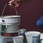professional painter holding bucket of paint