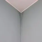 Water stains and uneven paint finish showing how humidity affects interior paint drying on an interior wall corner