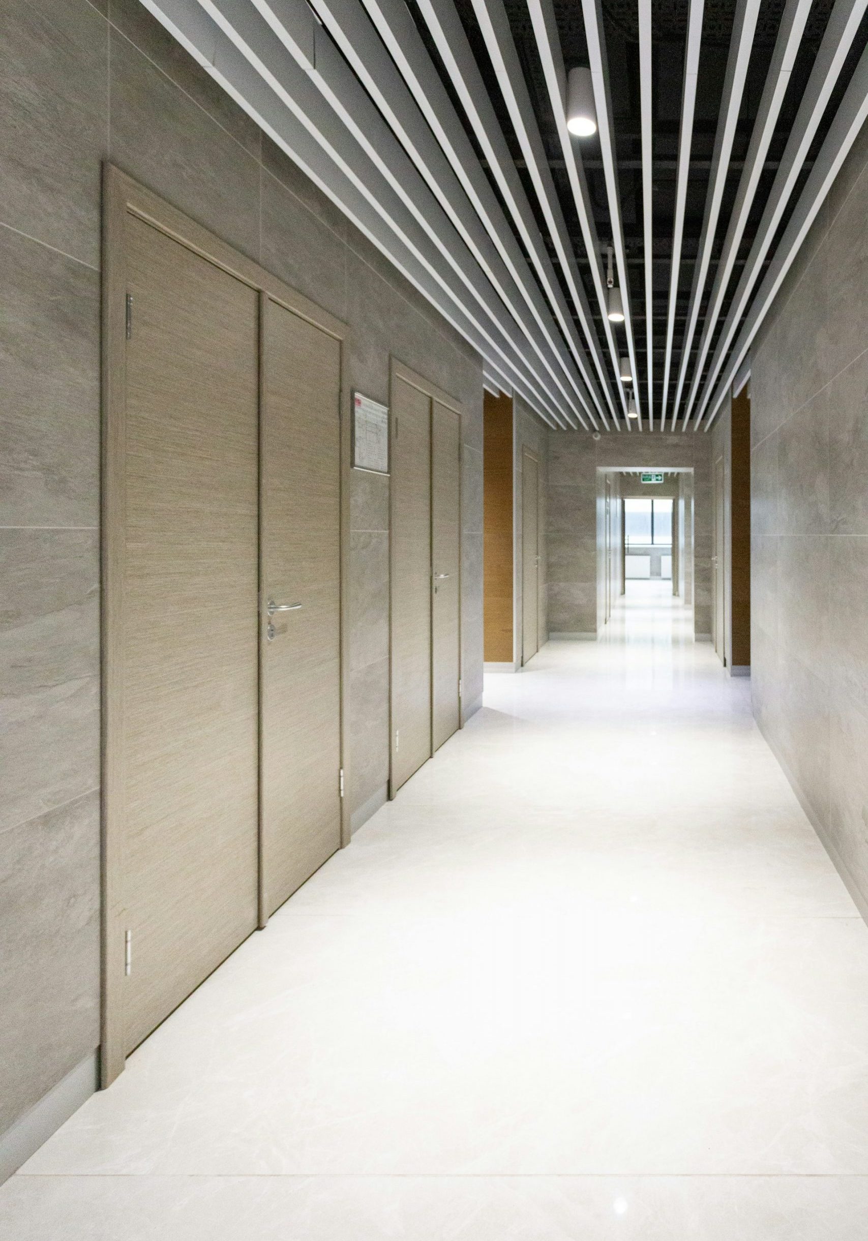 An unfinished residential basement with exposed concrete walls and floor, a white six-panel door, and framing for wooden stud walls and the ceiling joists overhead.
