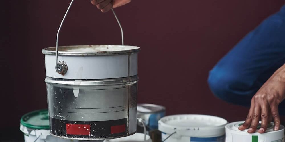 professional painter holding bucket of paint